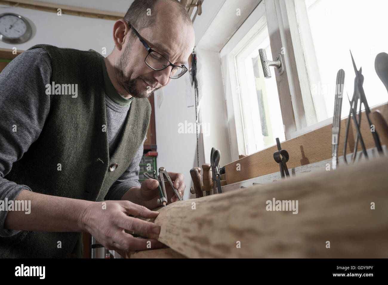Männliche Bogenmacher markieren auf Holz mit Kompass, Workshop, Bayern, Deutschland Stockfoto