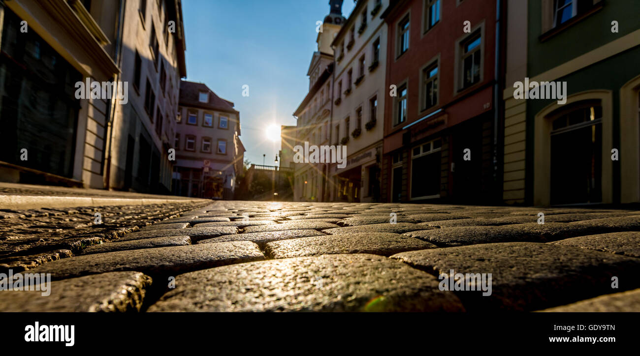 Sonnenaufgang in einer Stadt, die Straße mit Pflastersteinen Stockfoto