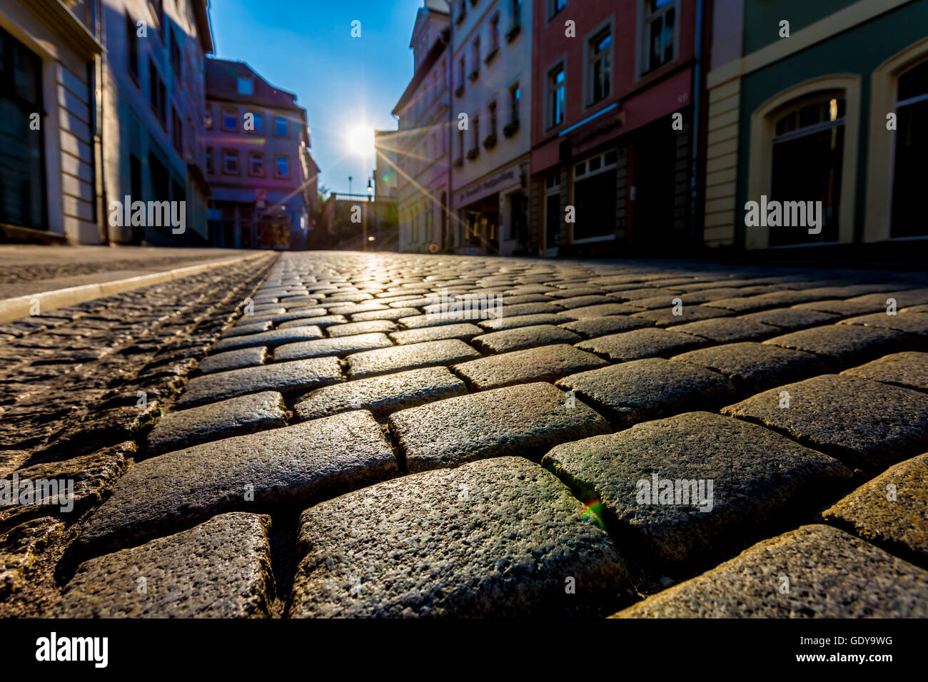 Sonnenaufgang in einer Stadt, die Straße mit Pflastersteinen Stockfoto