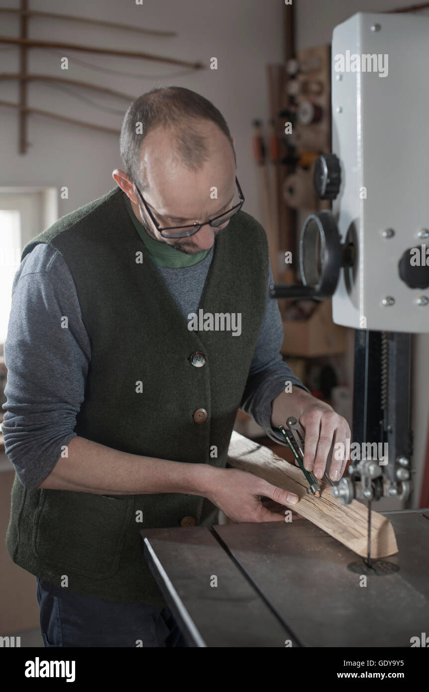 Männliche Bogenmacher markieren auf Holz mit Kompass, Workshop, Bayern, Deutschland Stockfoto