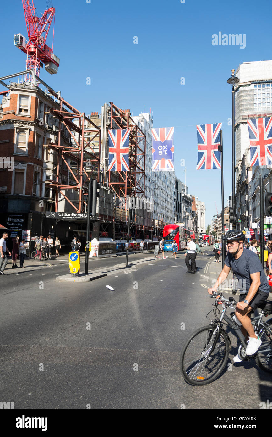 Union Jacks fliegen vor Centrepoint auf Londons Oxford Street, UK Stockfoto
