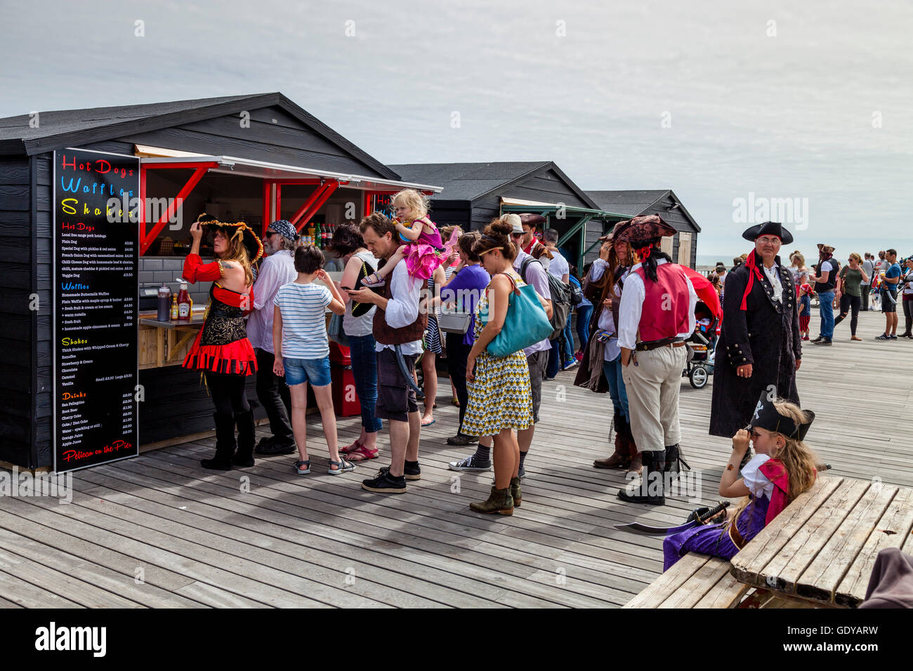 Menschen In Piraten Kostüme Schlange stehen, um Essen auf Hastings Pier in  Hastings Pirate Day Festival, Hastings, Sussex, UK zu kaufen  Stockfotografie - Alamy