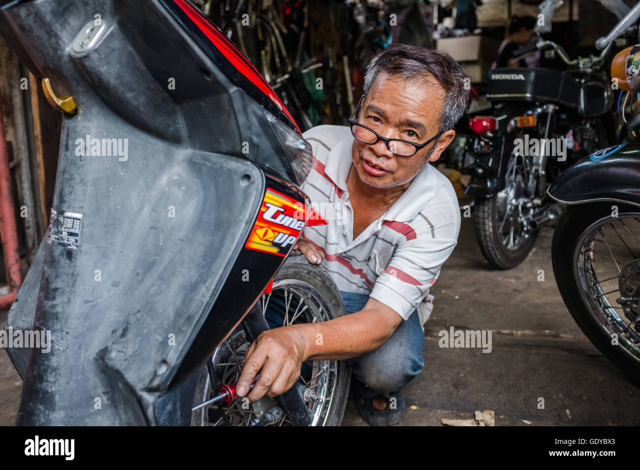 Thai Motorrad-Mechaniker bei der Arbeit Reparatur Fahrrad, zurück Straße Werkstatt Chiang Mai, Thailand Stockfoto