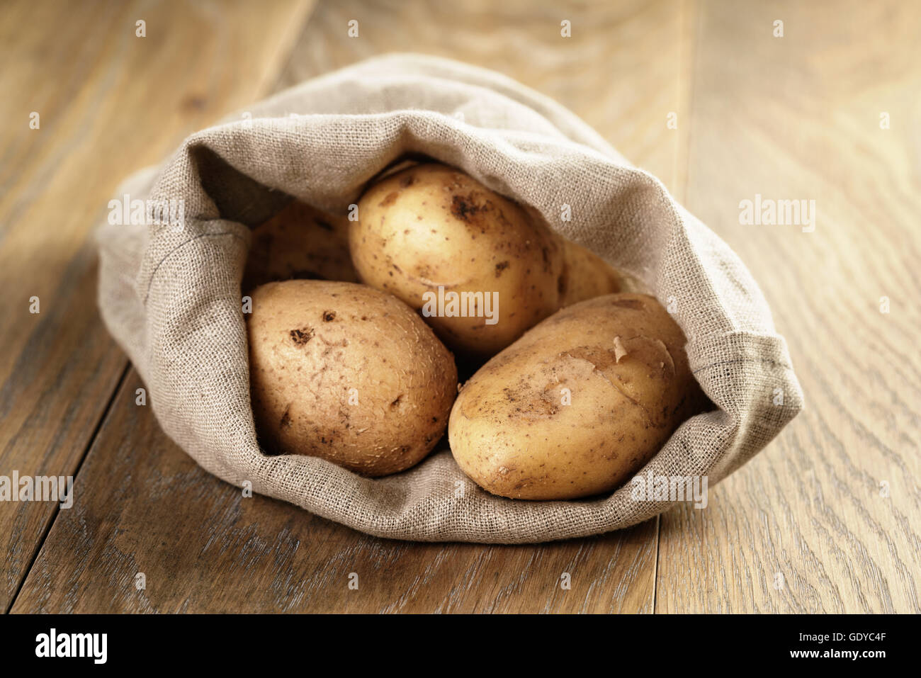 Sack voller Bio-Kartoffeln auf Eiche Holztisch Stockfoto