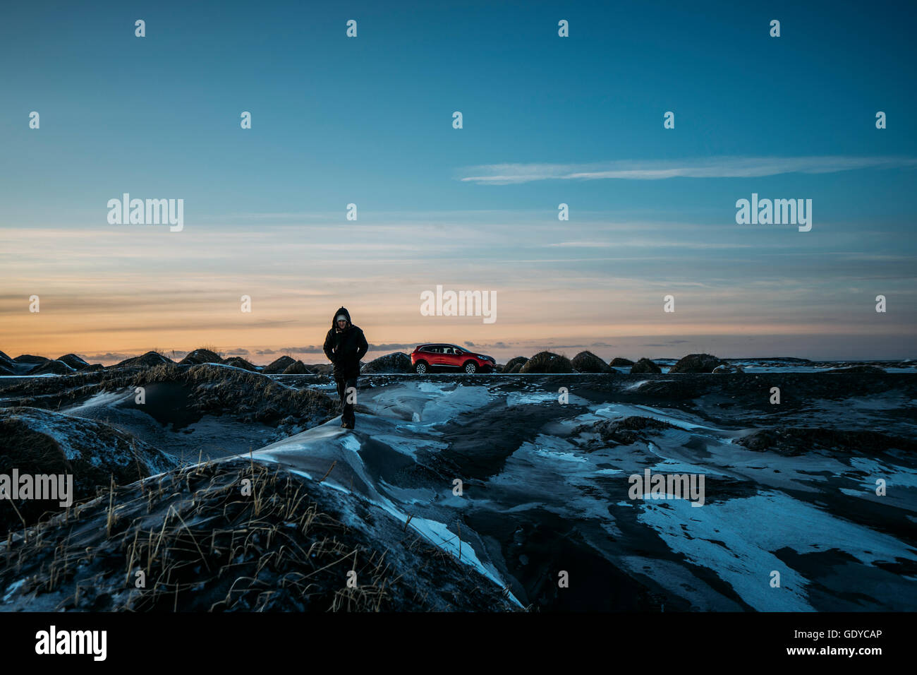 Mann zu Fuß auf eisigen Hügel in abgelegenen Landschaft, Hofn, Island Stockfoto