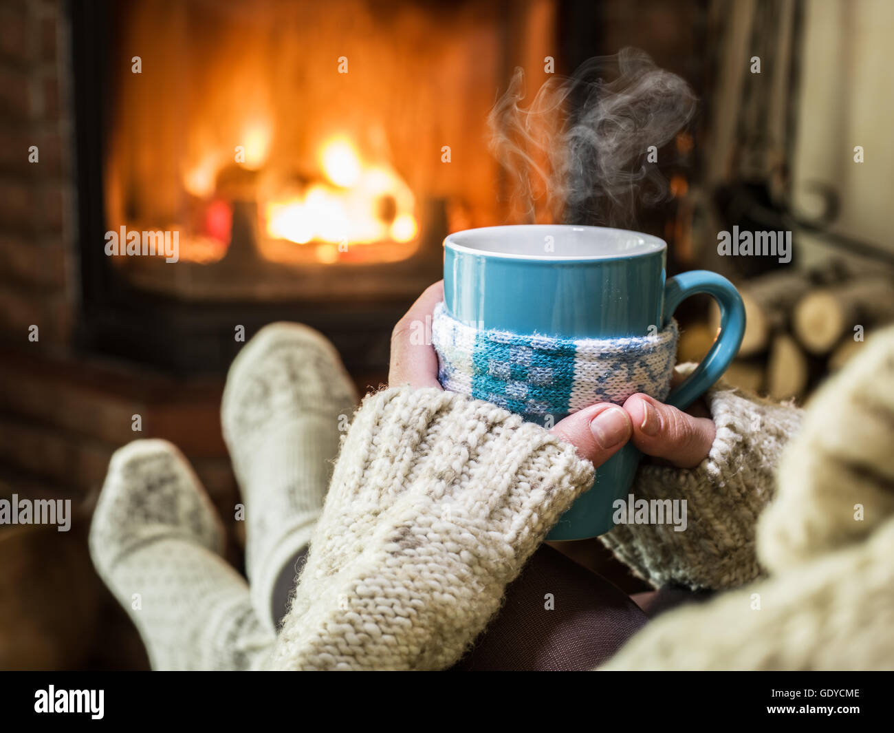 Erwärmung und Kamin mit einer Tasse heißes Getränk entspannen. Stockfoto