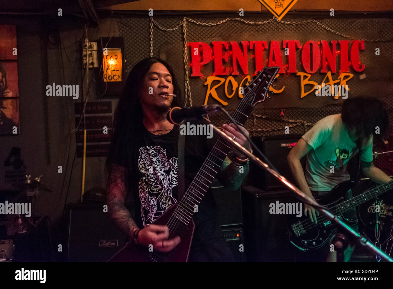e zigarette konzert Rock und Roll, Heavy-Metal-Band, Gitarrist auf der Bühne mit Zigarette im  Mund, Chiang Mai Thailand Stockfotografie