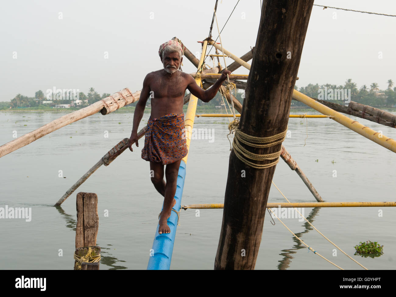 Ein Fischer steht auf einem chinesischen Fischernetz in Kochi, Indien, am 19. Oktober 2015. Foto: Sebastian Kahnert | weltweite Nutzung Stockfoto