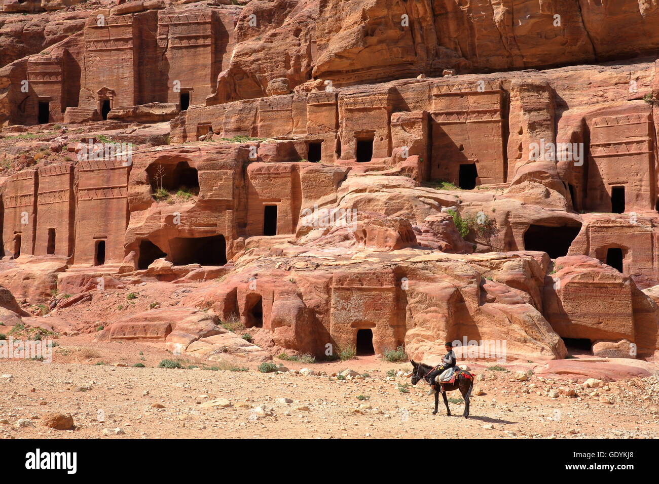 Die Straße von Fassaden in Petra, Jordanien, ein Beduine kleiner Junge reitet seinen Esel im Vordergrund Stockfoto