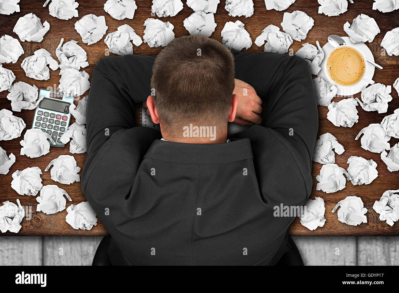 frustriert Geschäftsmann mit hatte am Tisch voll mit Papierkugeln Stockfoto