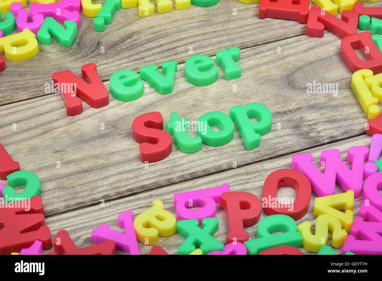 Nie aufhören Sie zu Wort auf Holztisch Stockfoto