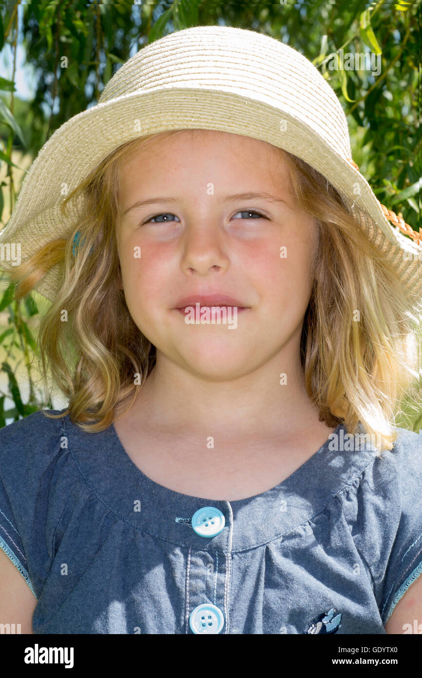 Kleines Mädchen mit Strohhut Stockfoto