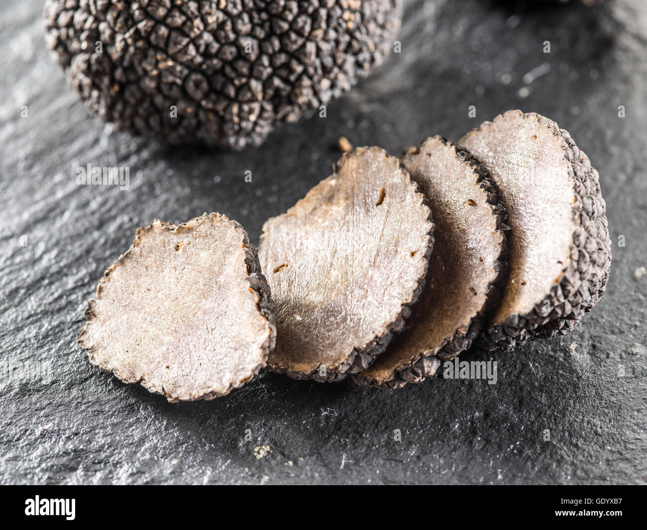 Trüffel-Scheiben auf dem Brett Graphit. Stockfoto