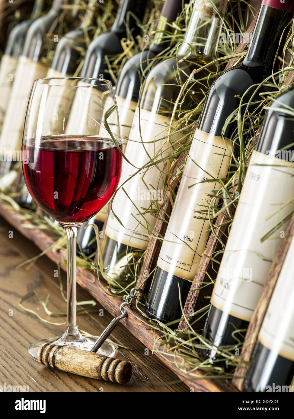 Glas Rot Wein und Flaschen auf dem Hintergrund. Stockfoto
