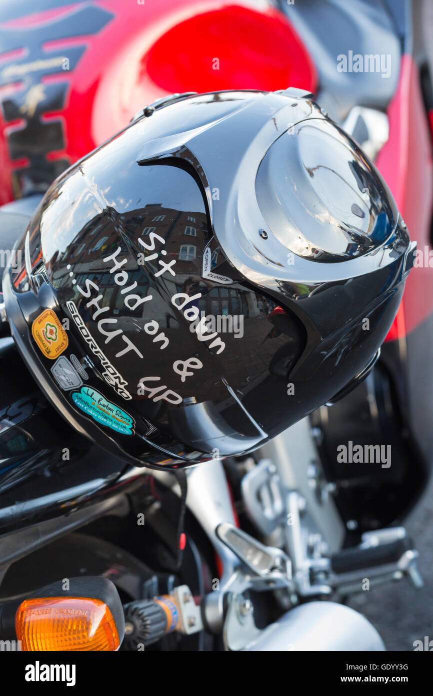 Setz dich halt auf und Klappe - detail auf Biker Helm am Motorrad bei Poole Traum Maschinen, Poole Quay im Juli Stockfoto