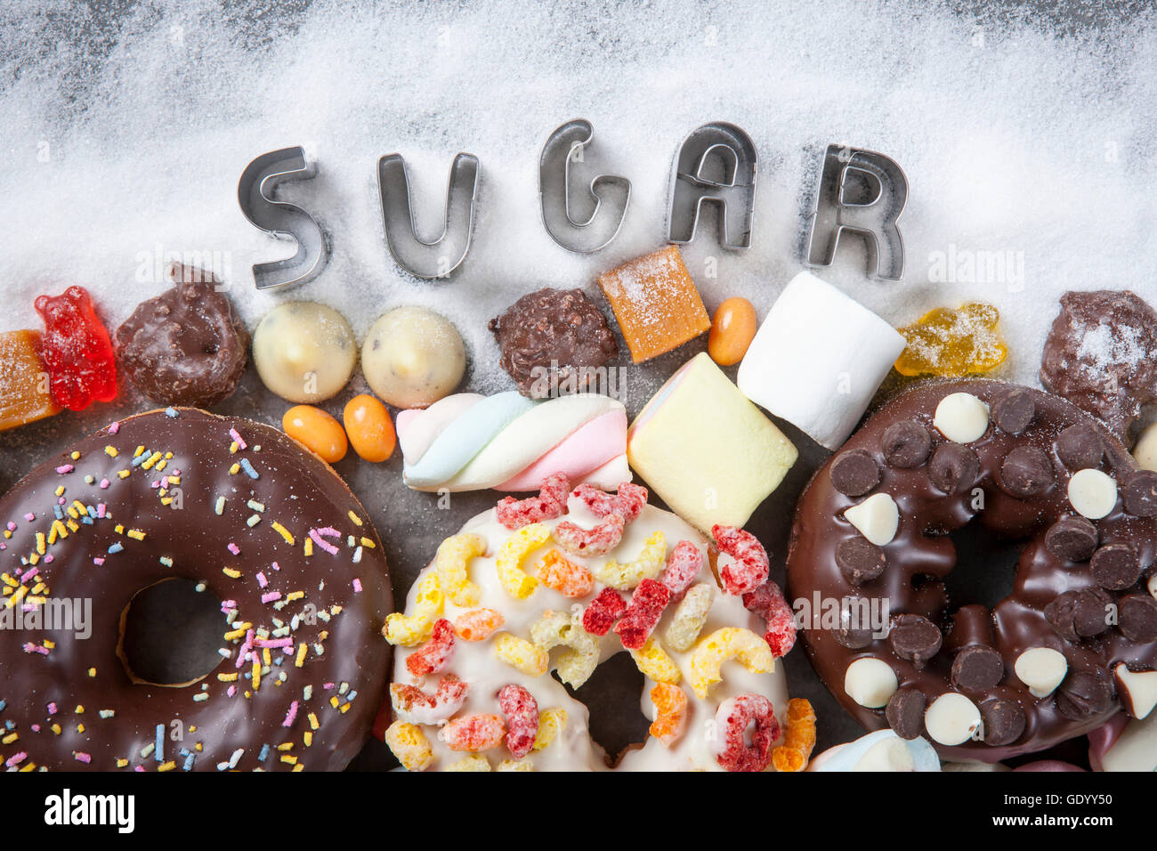 Typografische Wort Zucker und verschiedenen kalorienreiche Speisen wie Krapfen, Marshmallows und Gelees Stockfoto