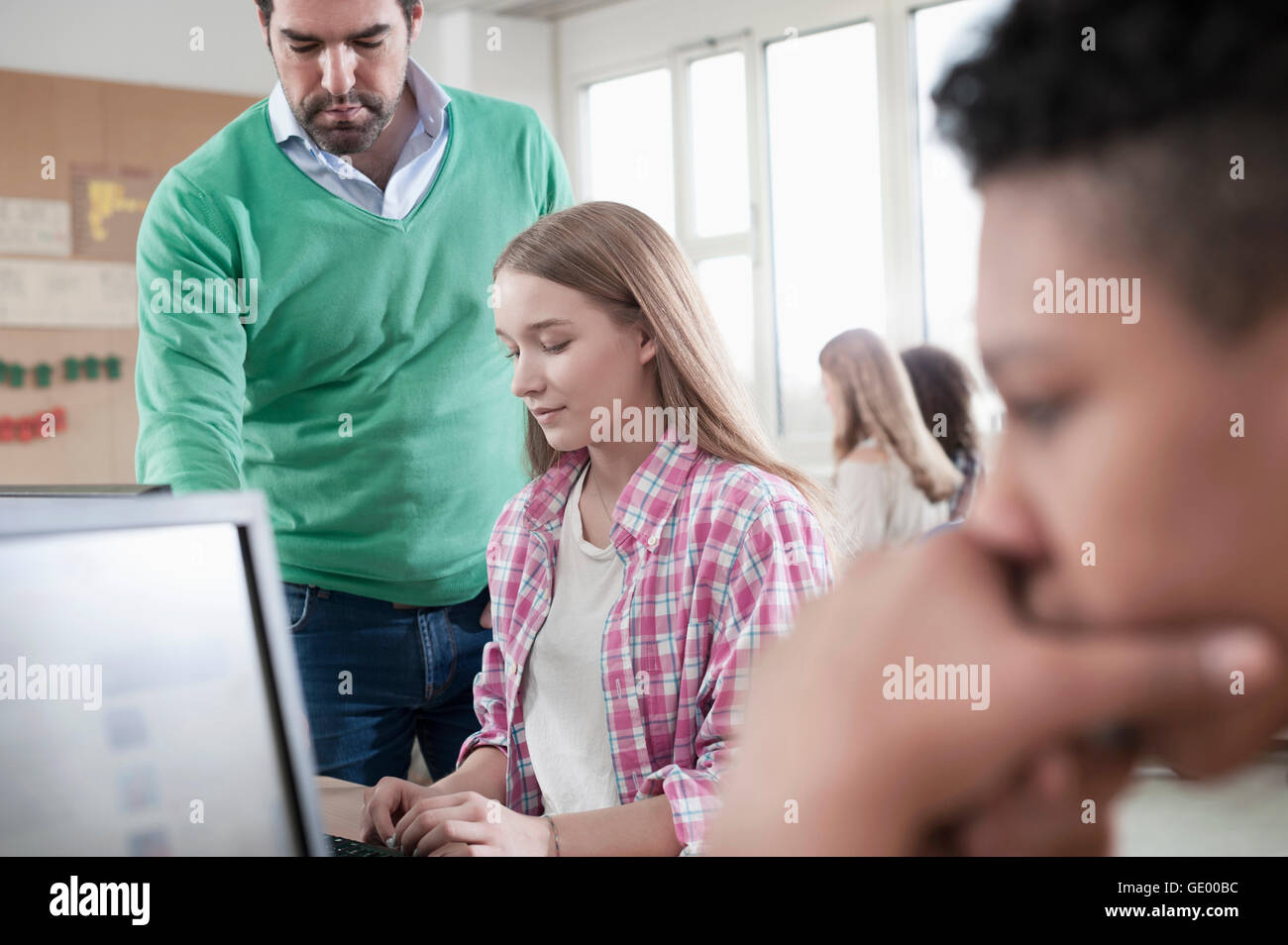 Lehrer-Explaning etwas am Computer im Computer Lab, Bayern, Deutschland Stockfoto