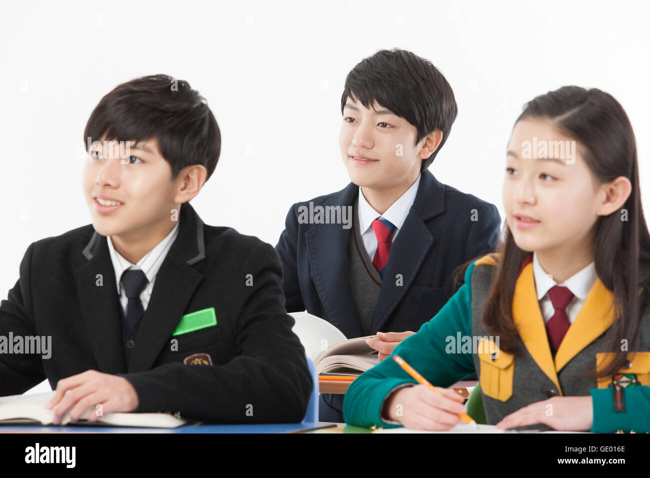 Porträt von drei Mittelschüler / innen konzentriert sich lächelnd Stockfoto
