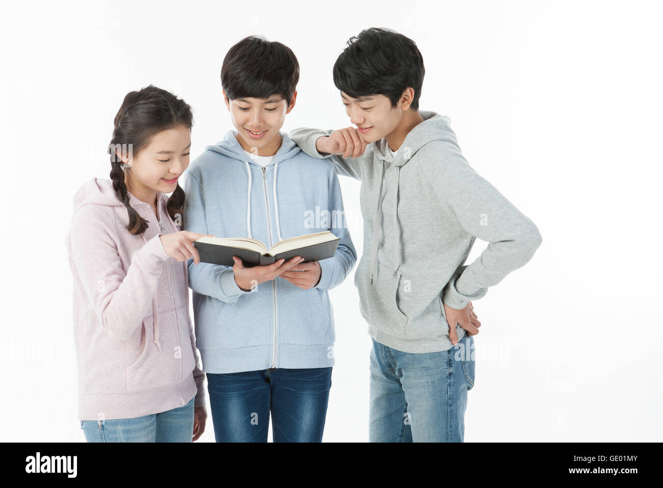 Drei lachende Jugendliche ein Buch Stockfoto