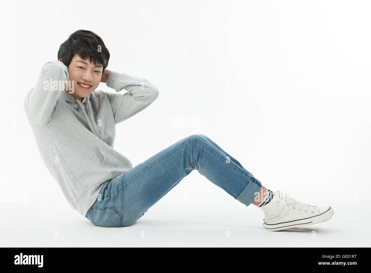 Seitenansicht des Lächelns Teenager junge tun Sit-up Stockfoto