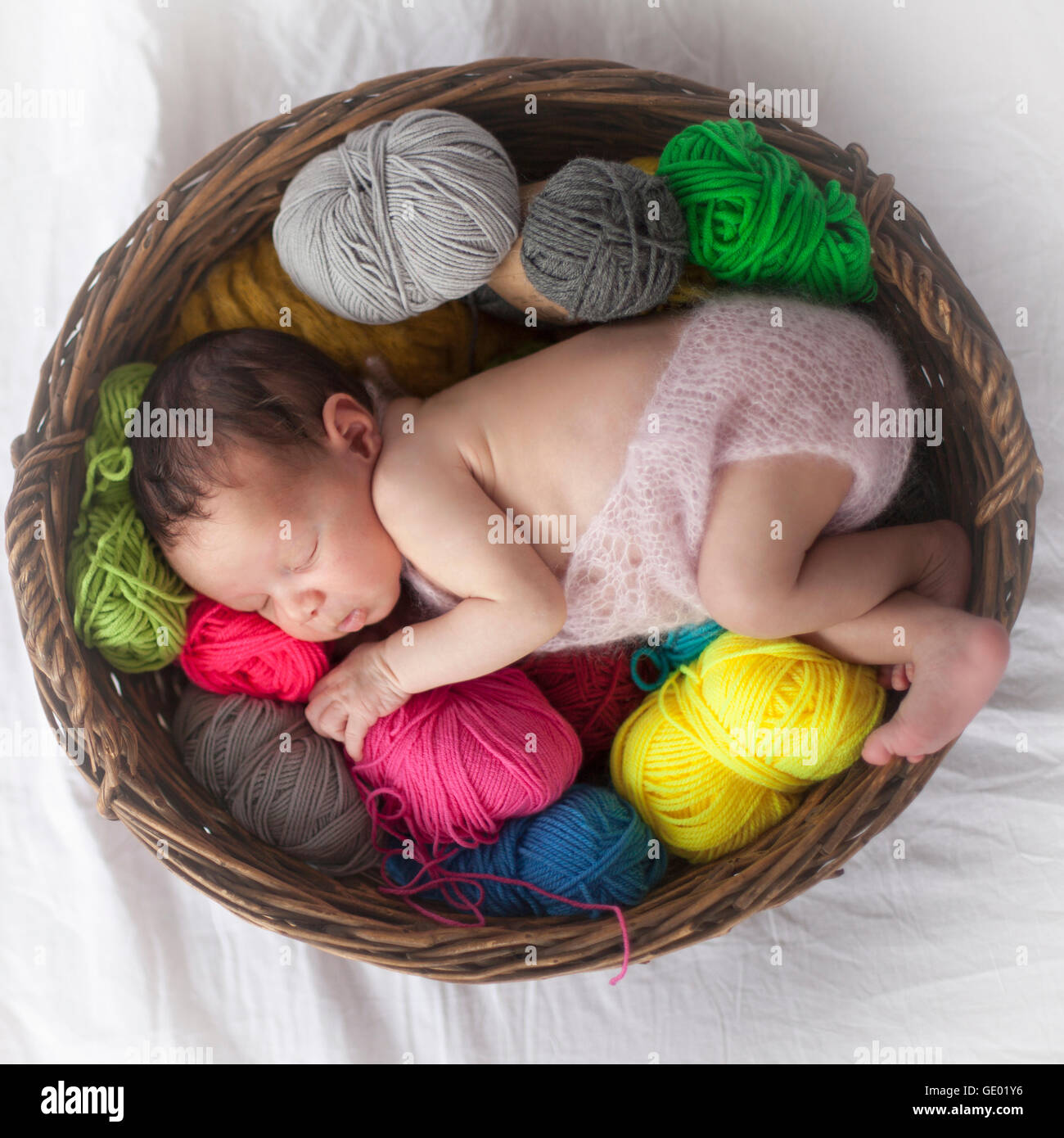 Niedlichen neugeborenen Mädchen schläft mit Ball aus Wolle im Korb, Fürstenfeldbruck, Bayern, Deutschland Stockfoto