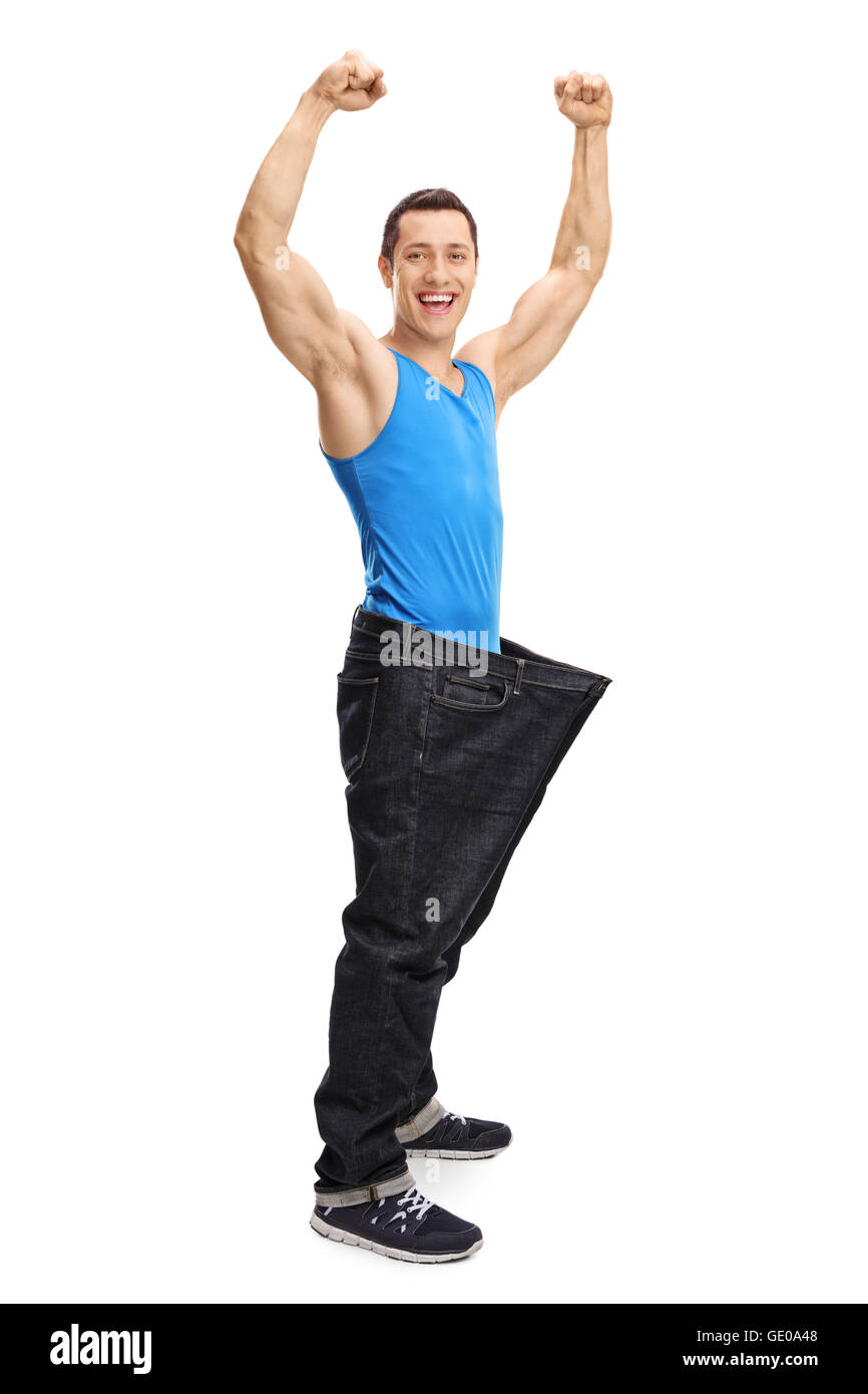 In voller Länge Portrait von ein glücklicher muskulösen Mann in ein paar übergroße Jeans isoliert auf weißem Hintergrund Stockfoto