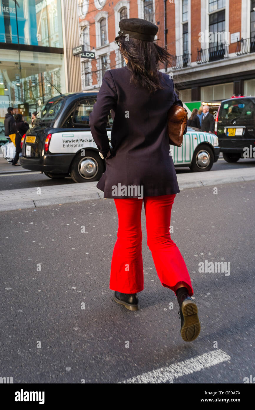 Junge modisch gekleidete Frau Kreuzung Straße, London, UK Stockfoto