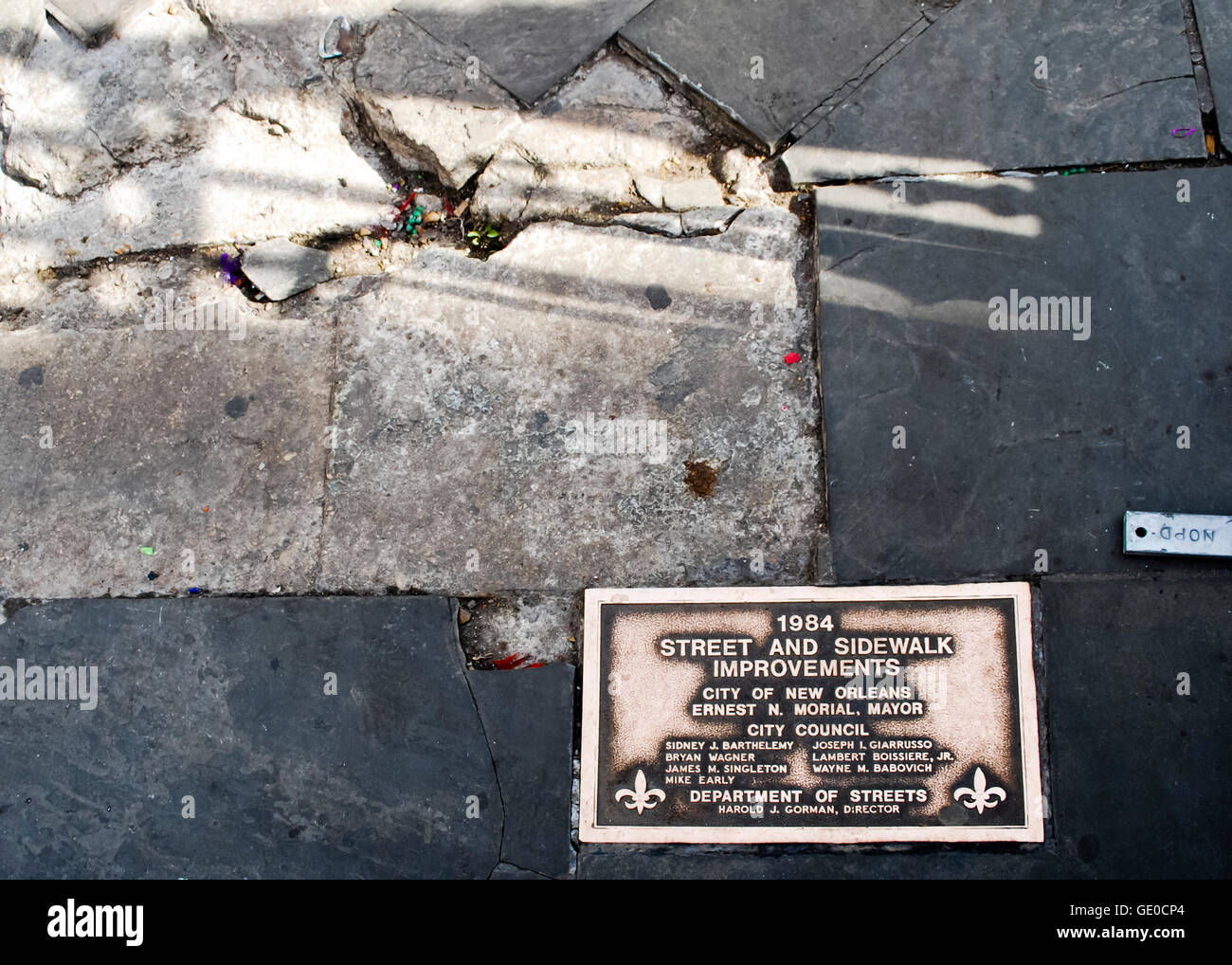 Gebrochene New Orleans Bürgersteig mit einer Plakette, eingebettet in das Feiern der Straße und Gehweg Verbesserungen. Stockfoto