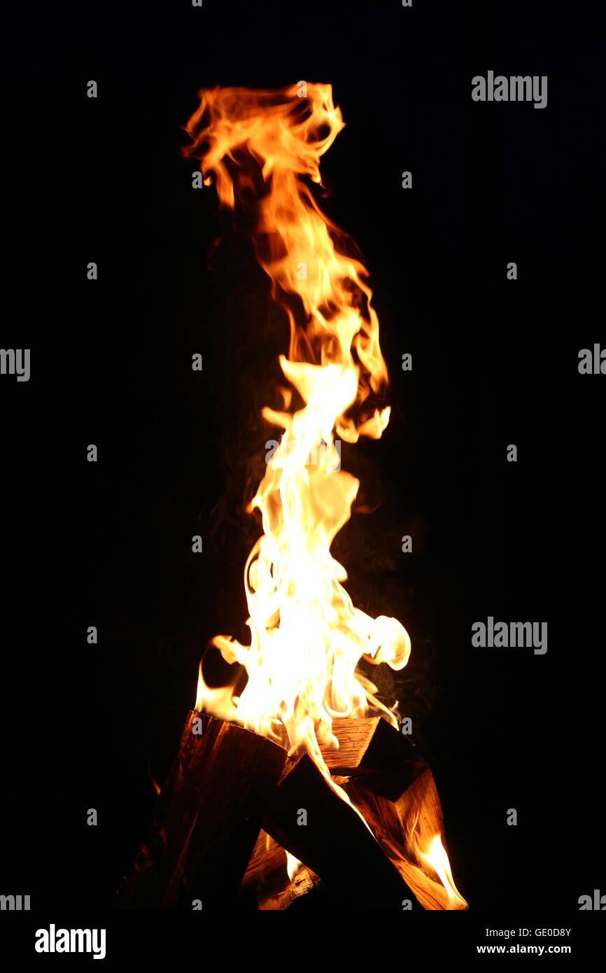 Flamme auf der Brennholz auf dem dunklen Hintergrund Stockfoto