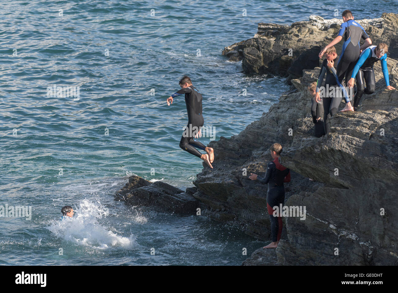 Eine Gruppe von Teenagern dieser Art der Kennzeichnung von den Klippen auf der Landzunge in Newquay, Cornwall Stockfoto