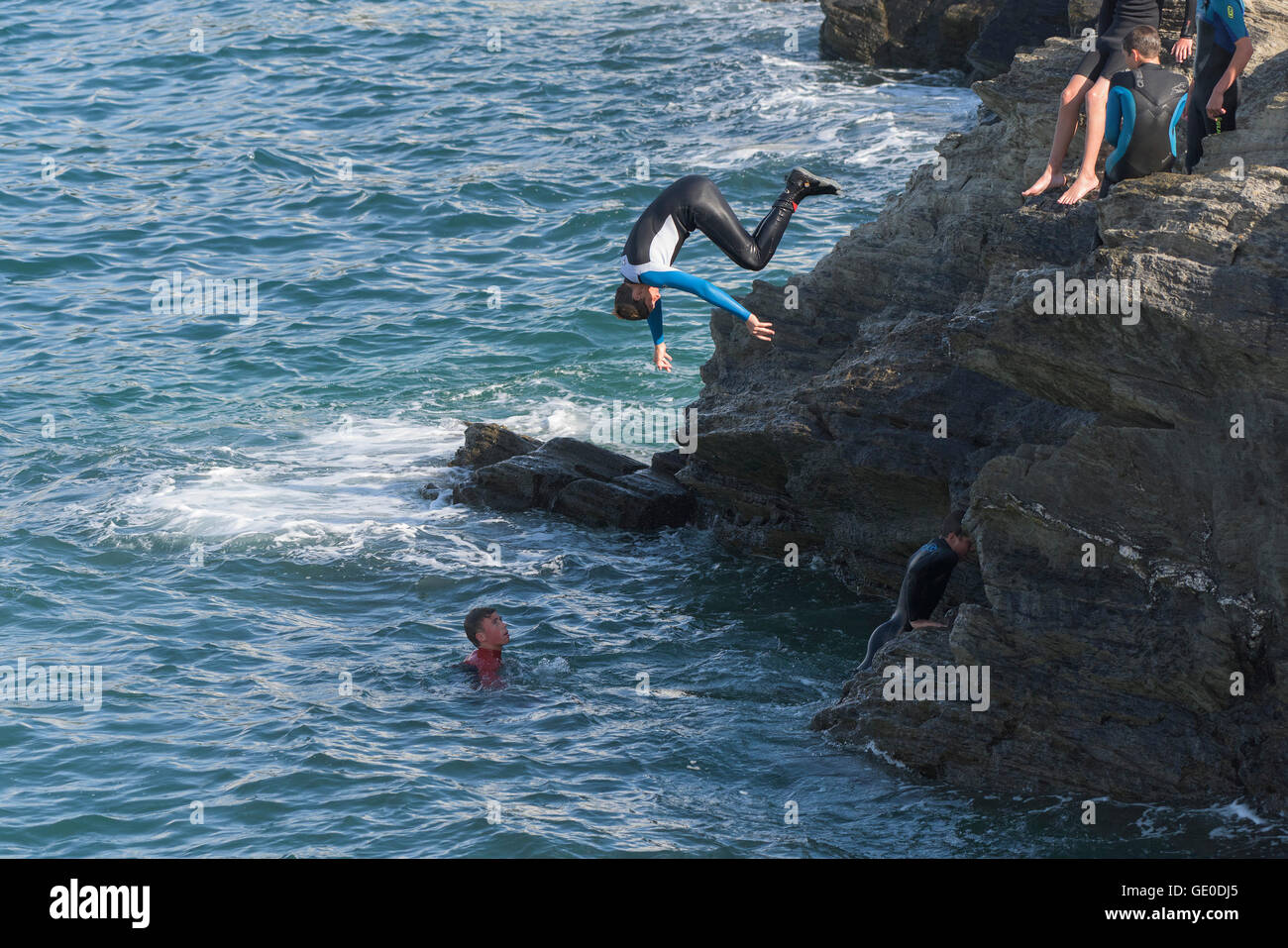 Eine Gruppe von Teenagern dieser Art der Kennzeichnung von den Klippen auf der Landzunge in Newquay, Cornwall. Stockfoto