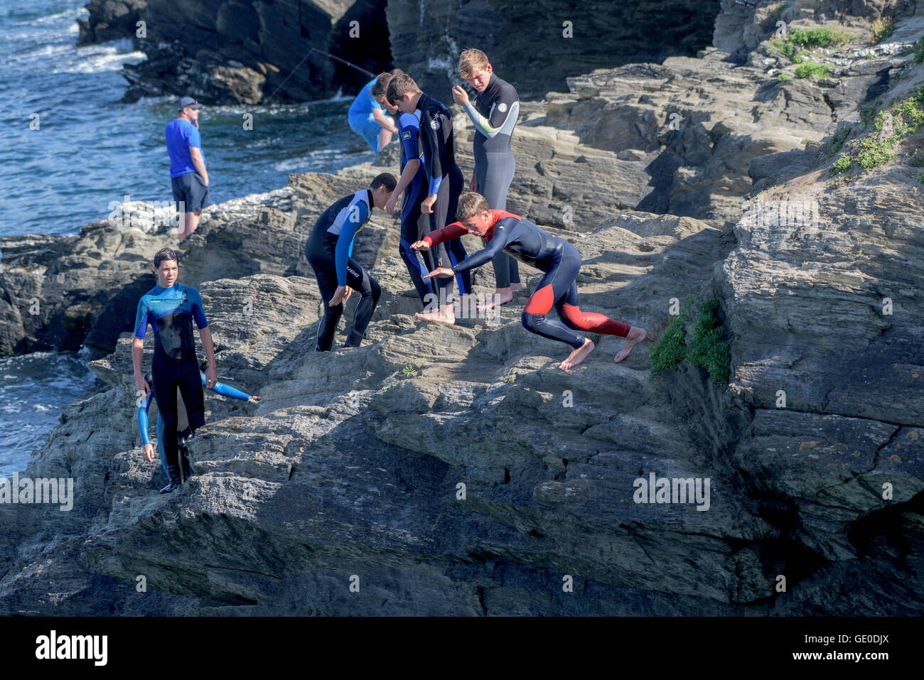 Eine Gruppe von Teenagern dieser Art der Kennzeichnung von den Klippen auf der Landzunge in Newquay, Cornwall. Stockfoto