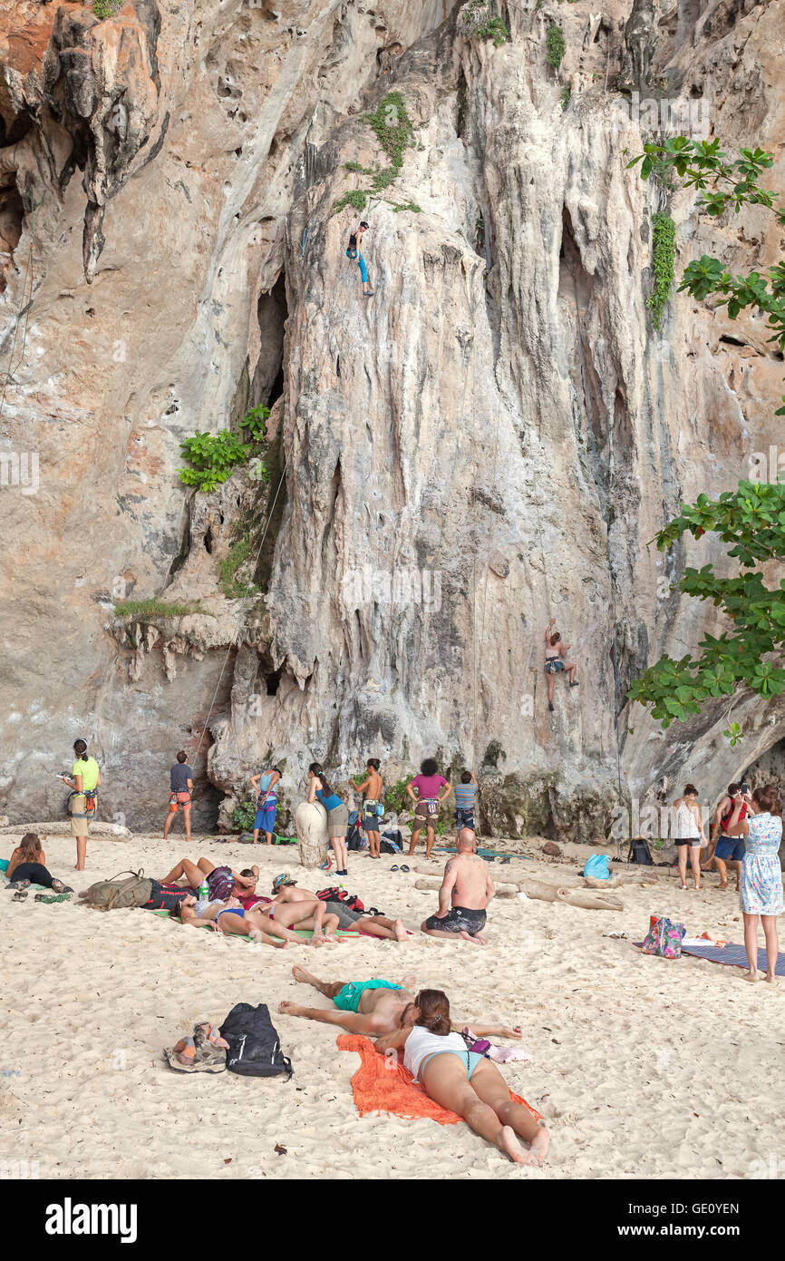 Touristischen Kletterer die Kletterwand am Railay Strand beobachten. Stockfoto