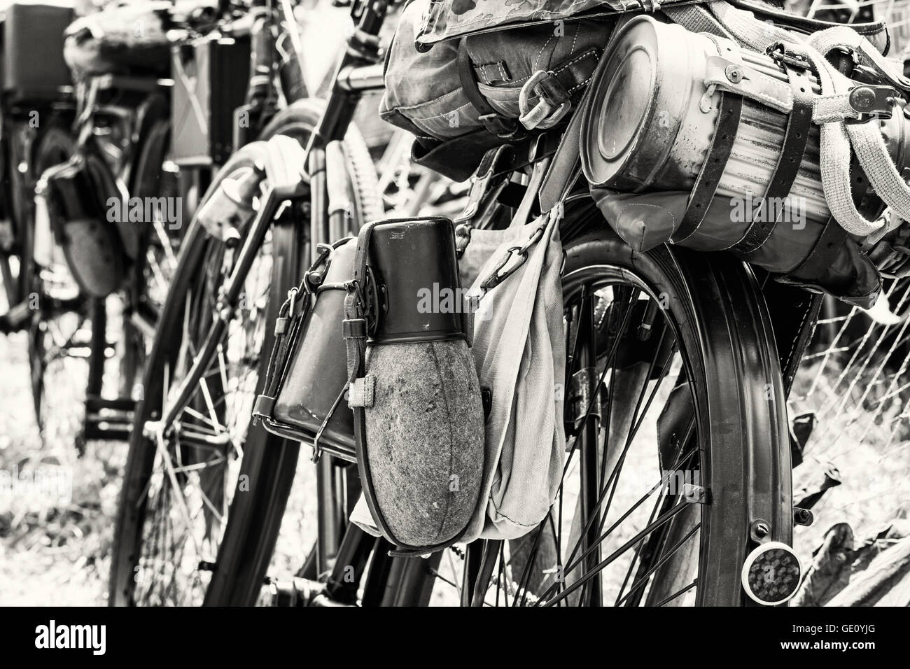 Alte militärische Fahrrad mit kramt und Ausrüstungen. Rucksack und Behälter für Speisen und Getränke. Vintage-Szene. Schwarz und weiß. Stockfoto