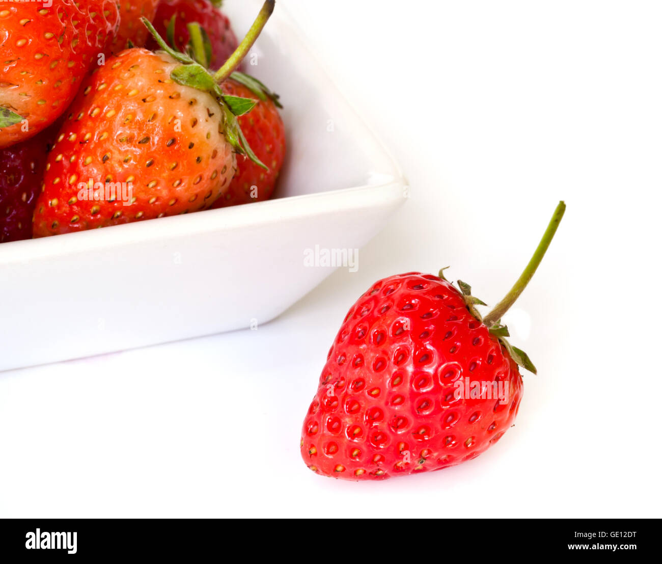 rote, reife Erdbeeren auf einem weißen Teller. Stockfoto