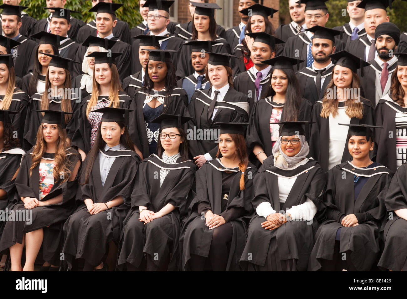 Absolventen aus vielen verschiedenen Kulturen, die seinem Abschluss an der University of Birmingham, Birmingham UK - Konzept - multikulturelles Großbritannien Stockfoto