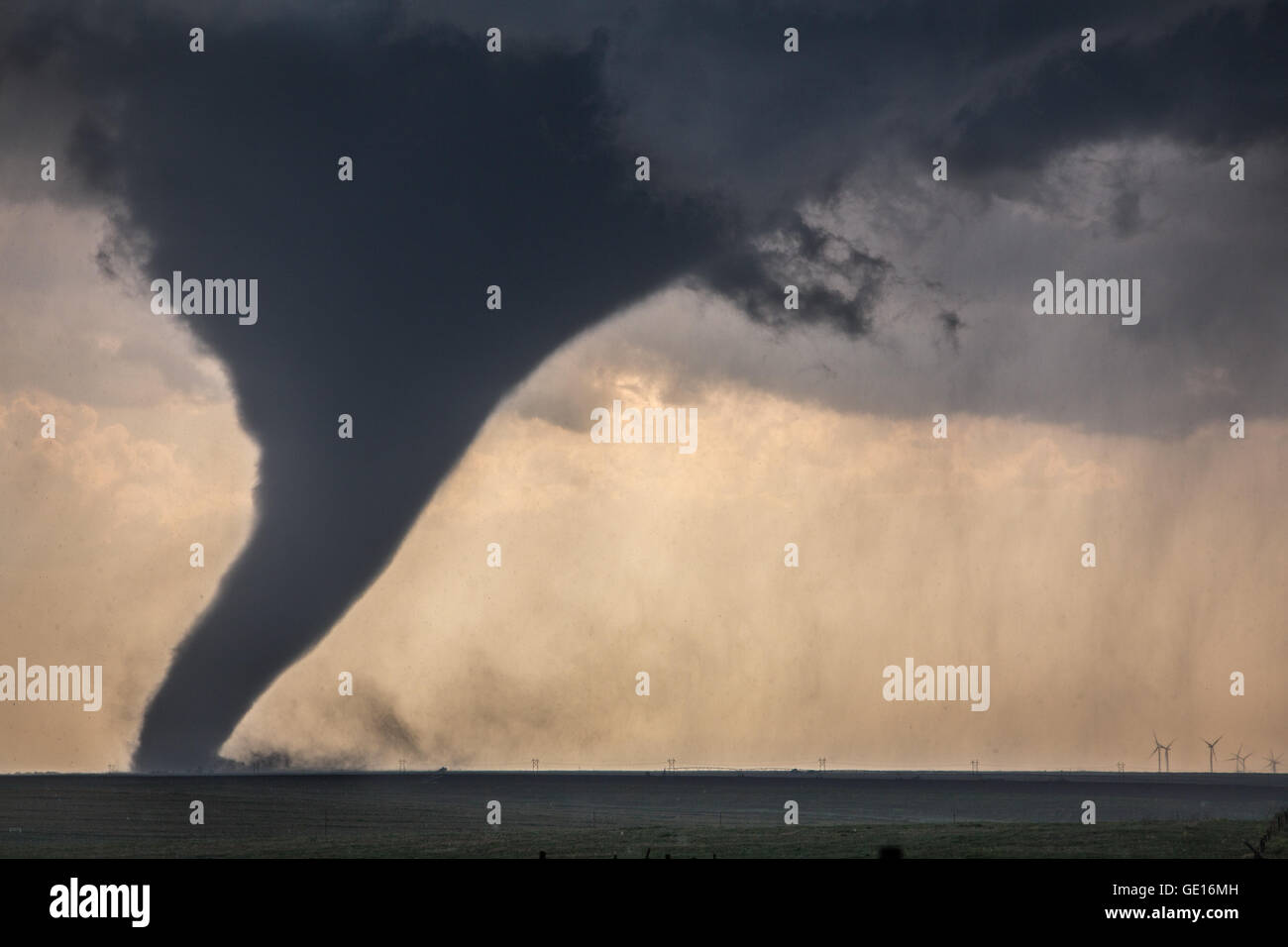Ein Tornado stammt aus einer superzelle in der Nähe von Dodge City, Kansas, 24. Mai 2016. Wind Generatoren sind im Hintergrund. Stockfoto