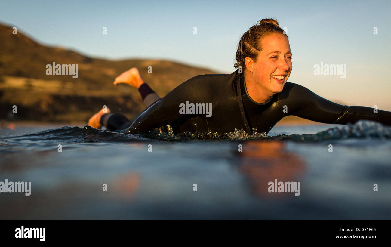 Nahaufnahme einer Frau, die auf dem Surfbrett paddelt, Malibu, Kalifornien, USA Stockfoto