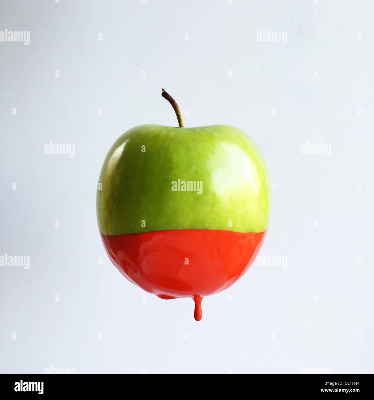 Grüner Apfel in roter Farbe getaucht Stockfoto