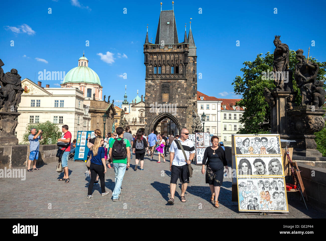 Touristen, Straßenkünstler und Anbieter auf der Karlsbrücke. Stockfoto