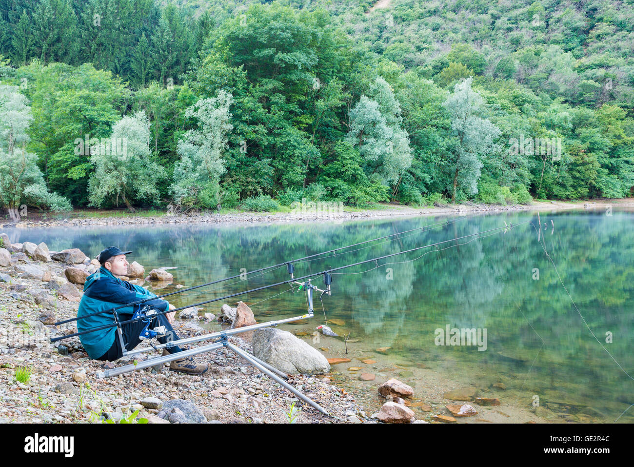 Angeln Adventures, Karpfen angeln. Fischer am Ufer eines Sees Stockfoto