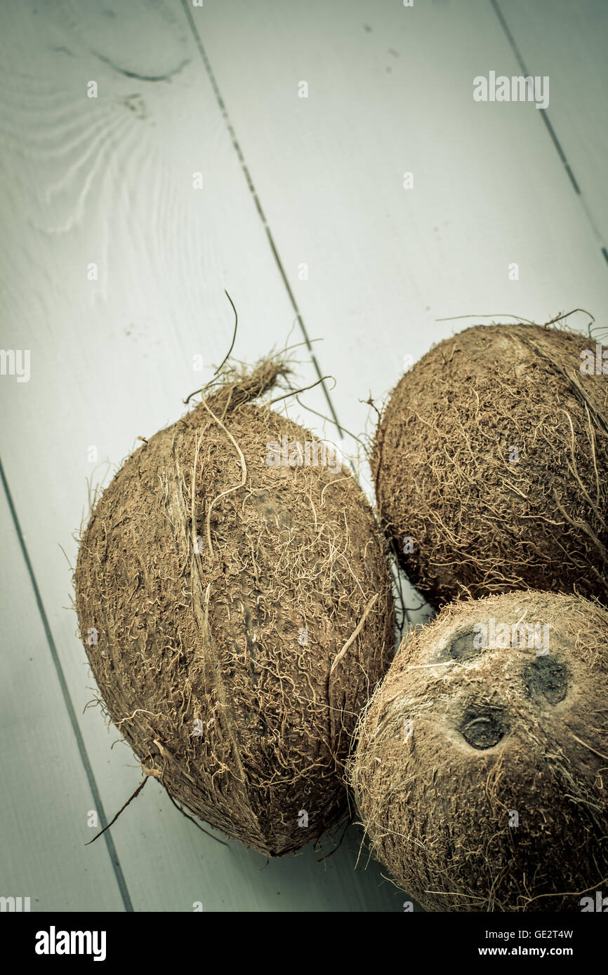 Drei Teilen nicht Kokosnüsse, auf einem Holzbrett weißen Hintergrund. Einige Kokosnüsse in der Gruppe. Stockfoto