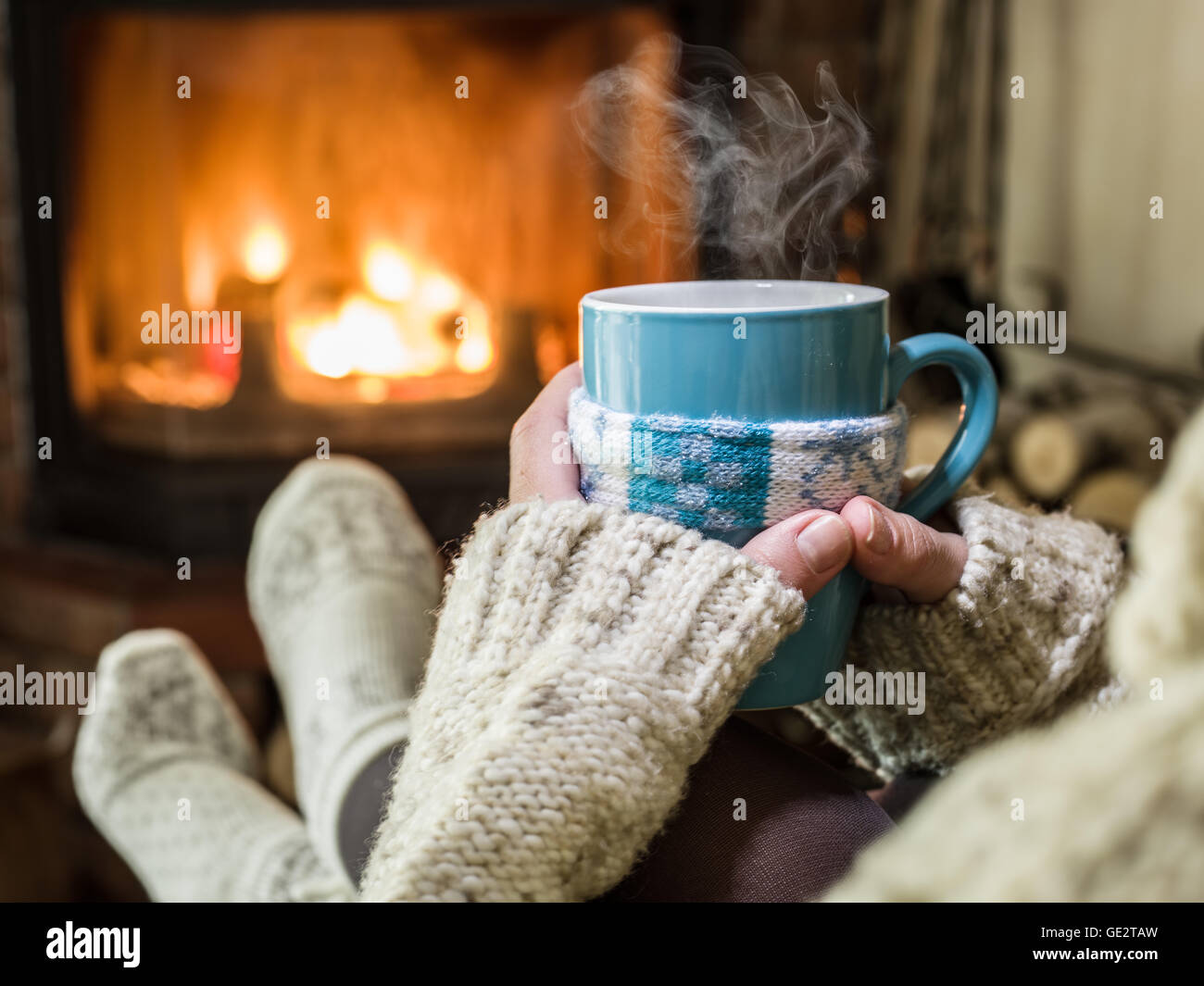 Erwärmung und Kamin mit einer Tasse heißes Getränk entspannen. Stockfoto