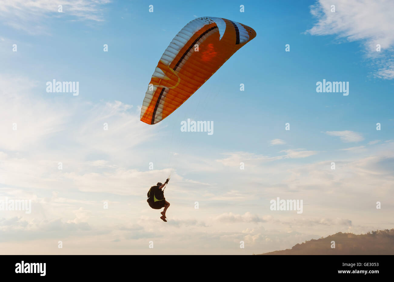 Mann mit Schirm auf den blauen Himmel und weiße Wolke im Abendlicht Stockfoto