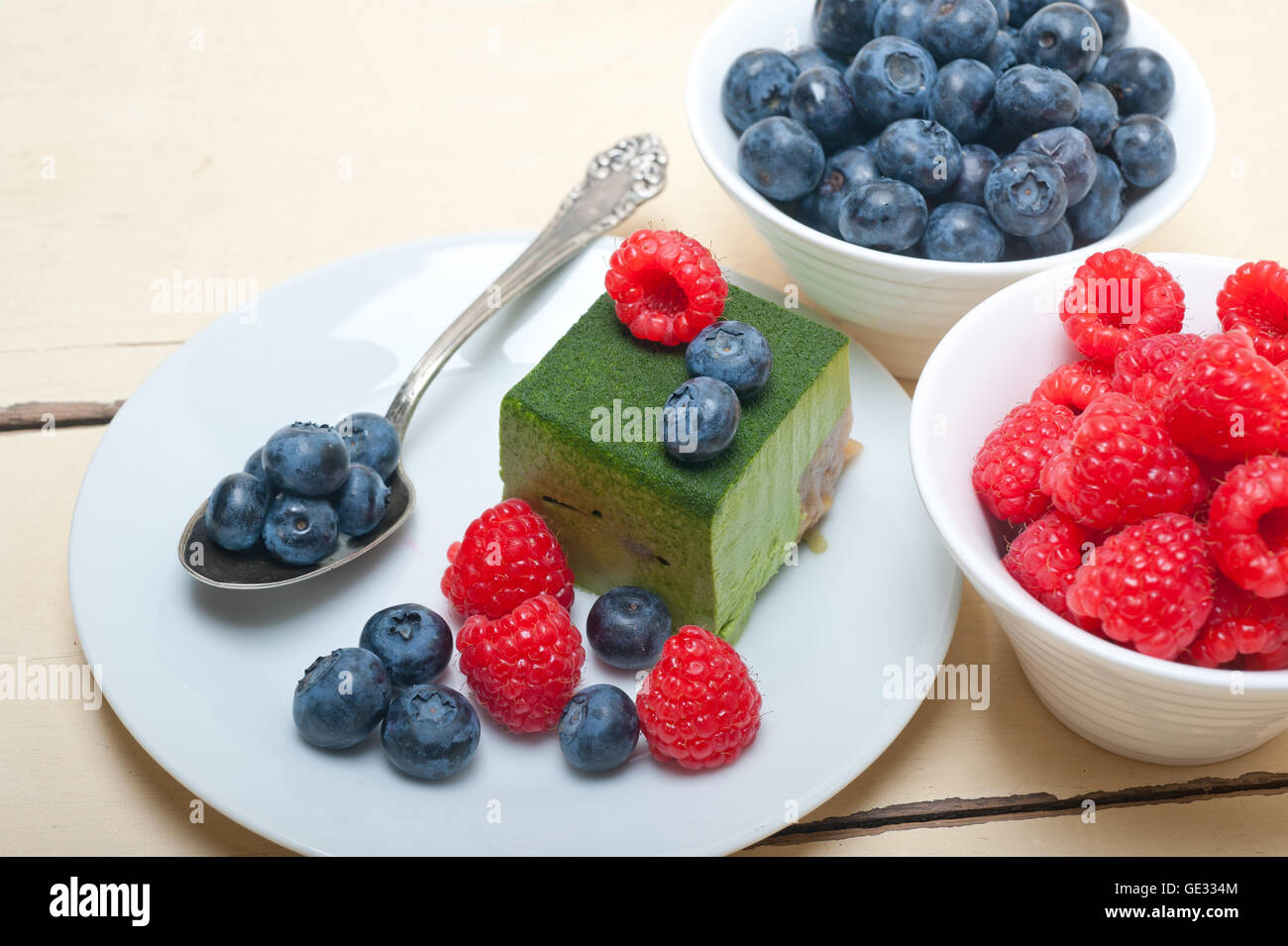 Grüner Tee Matcha Mousse Torte mit Himbeeren und Heidelbeeren an der Spitze Stockfoto