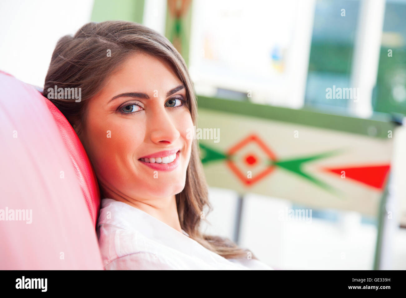 Portrait der schönen Frau lächelnd. Gerne hübsche Frau ist entspannend auf Sofa. Sie ist mit zuversichtlich Blick auf ihrem Gesicht zu Hause Stockfoto