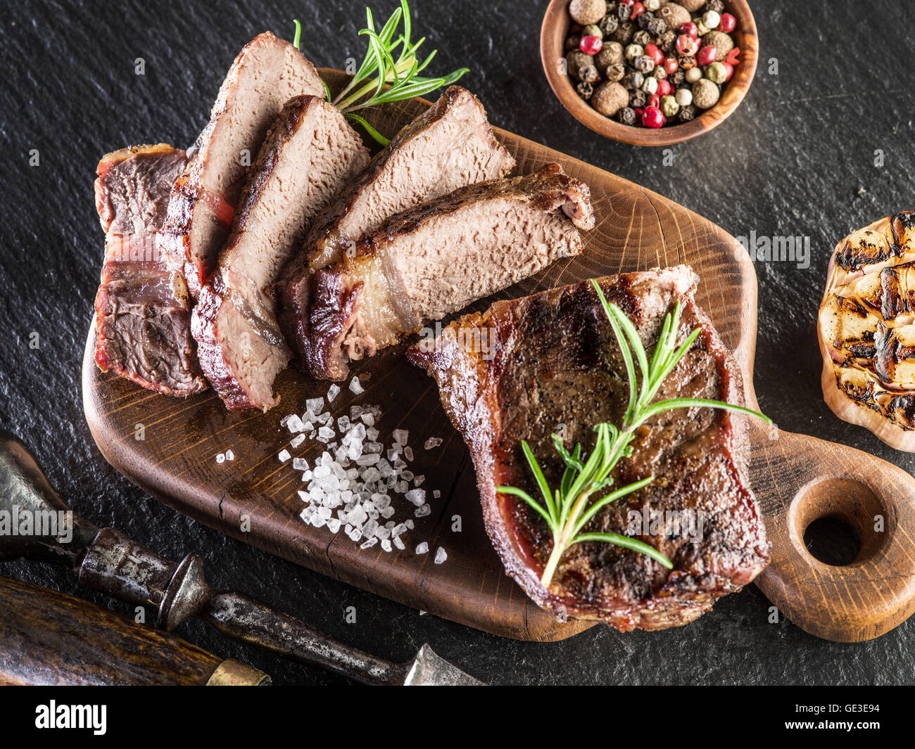 Rib-Eye Steak mit Gewürzen auf dem Tablett aus Holz. Stockfoto