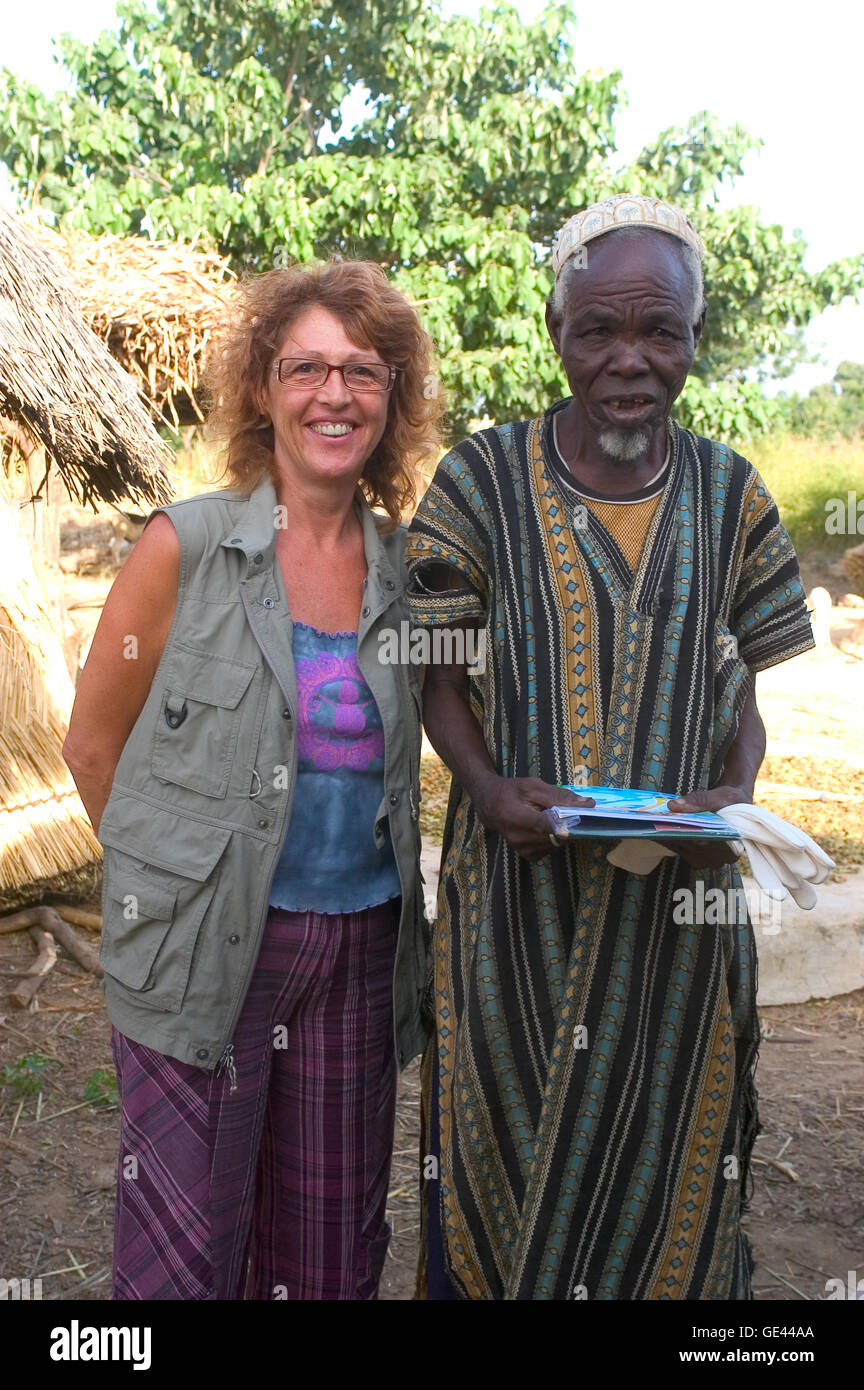 ein französischer Tourist macht einen Besuch in einem Dorf in Burkina Faso und freundet sich mit der Dorfvorsteher Stockfoto