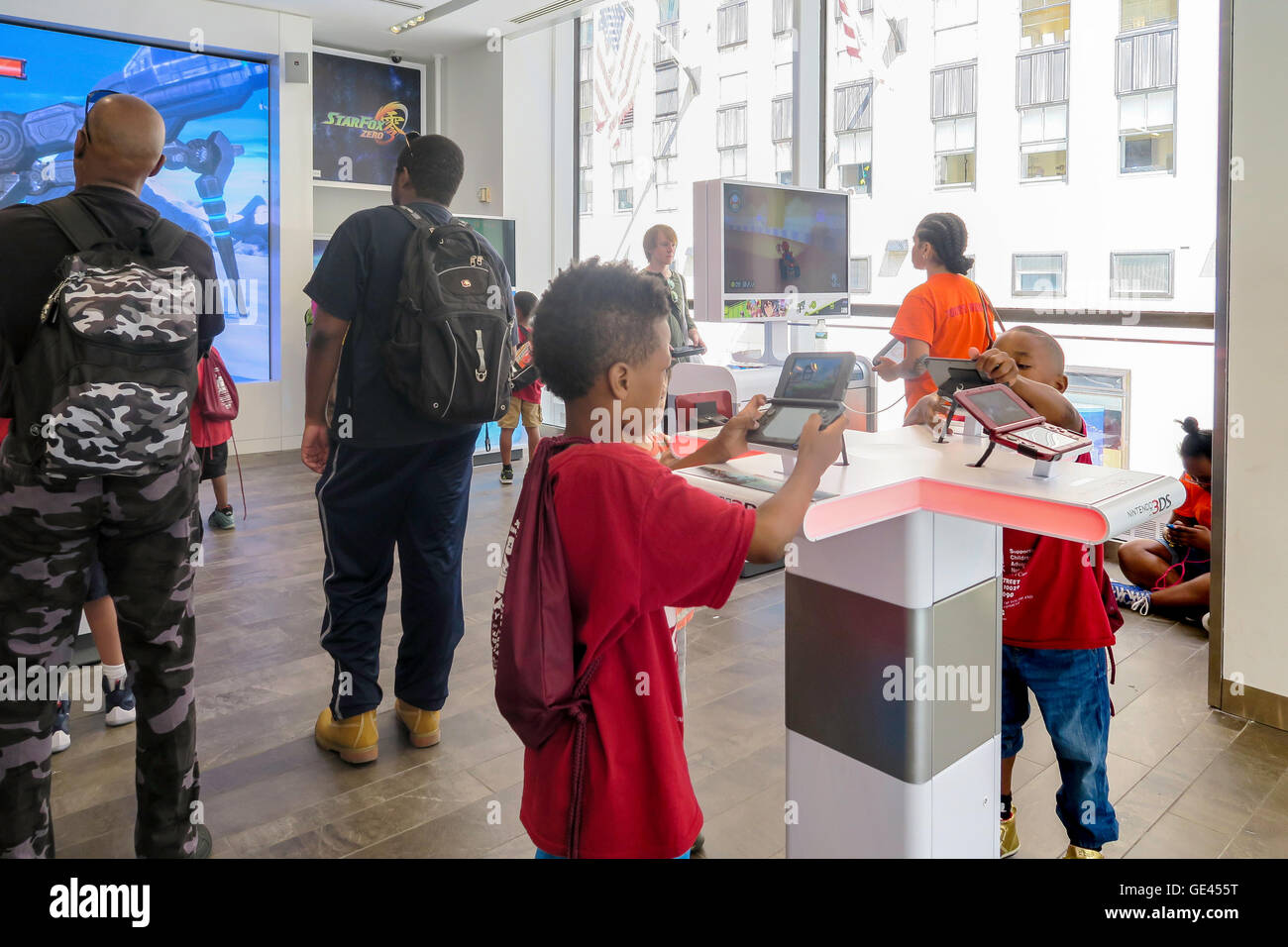 Jungen spielen mit Spiel-Konsole, Nintendo New York Store Interieur, Rockefeller Center, NYC, USA Stockfoto