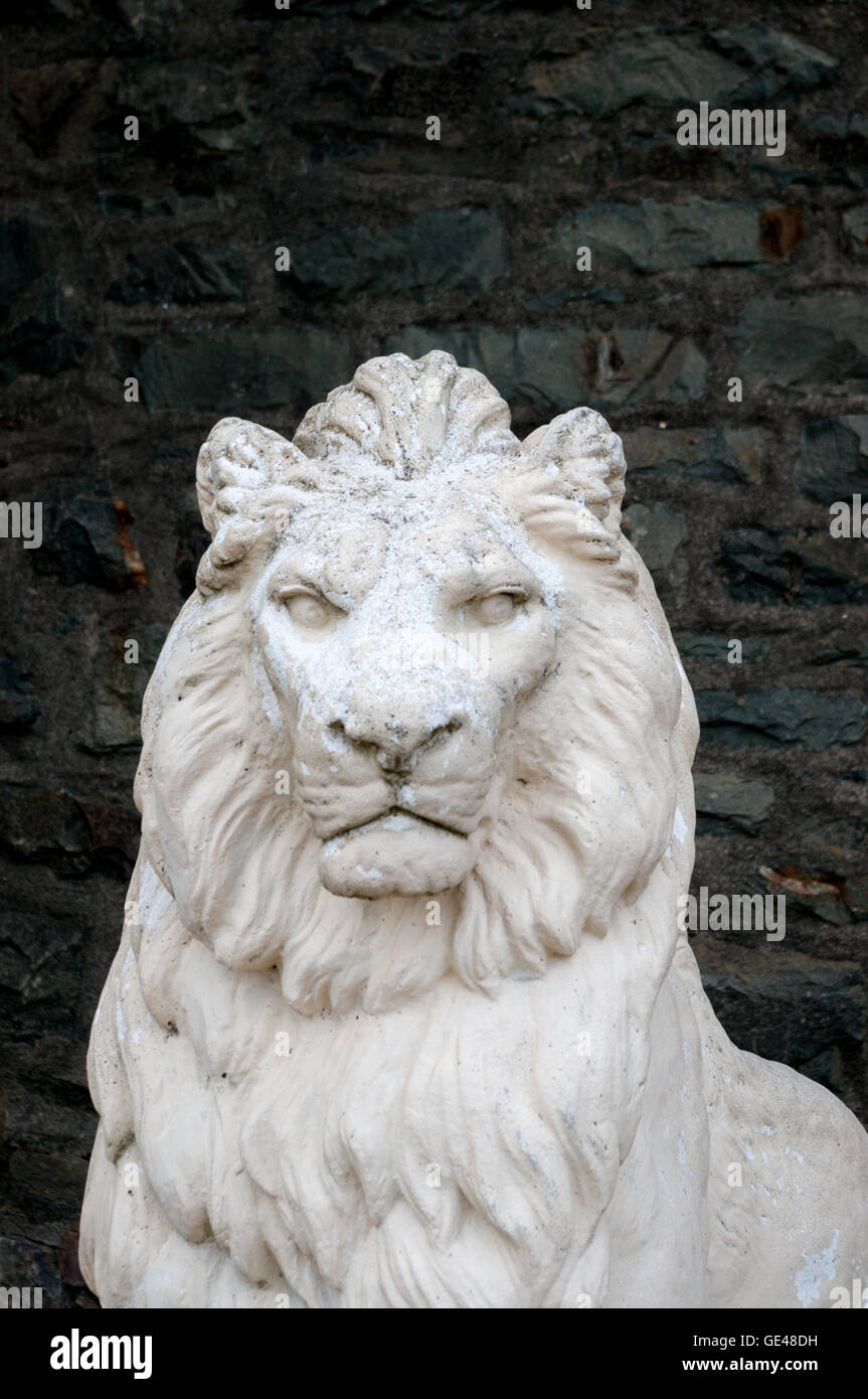 Weißer Löwenstatue vor einem dunklen Hintergrund Stockfoto